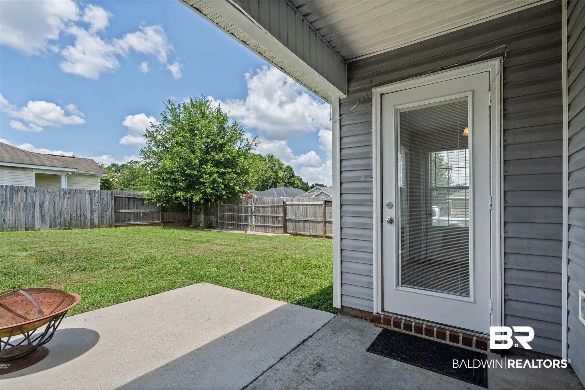 8980 Spring Grove North Mobile, AL 36695 - Photo 17 of 24 Covered patio opening to a fenced backyard featuring a mature tree