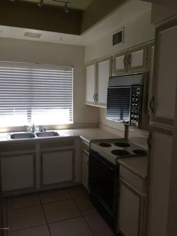 a kitchen with granite countertop a sink and cabinets