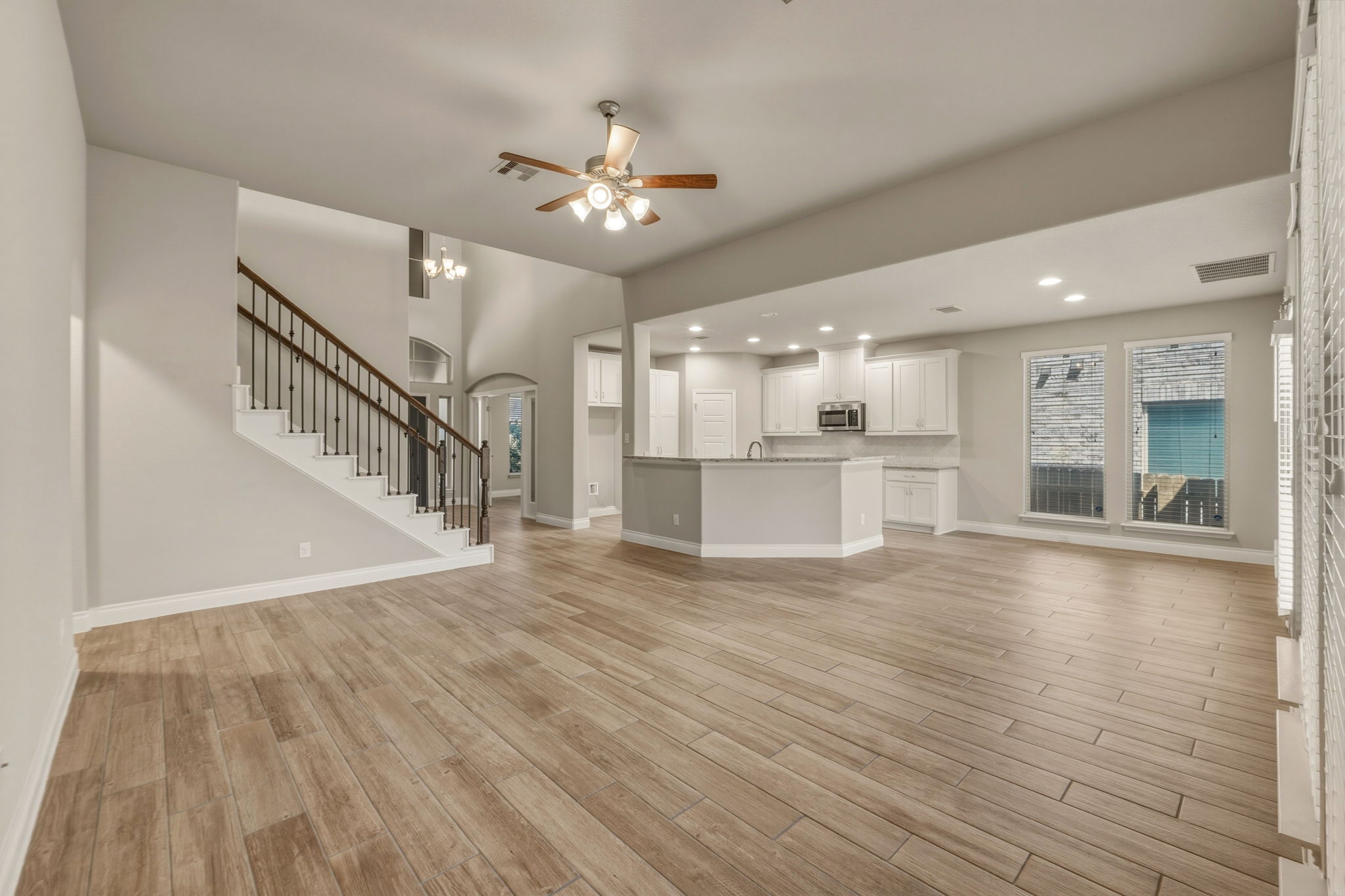 1320 Low Branch Lane Leander, TX 78641 - Photo 10 of 38 a view of an empty room with wooden floor and a kitchen