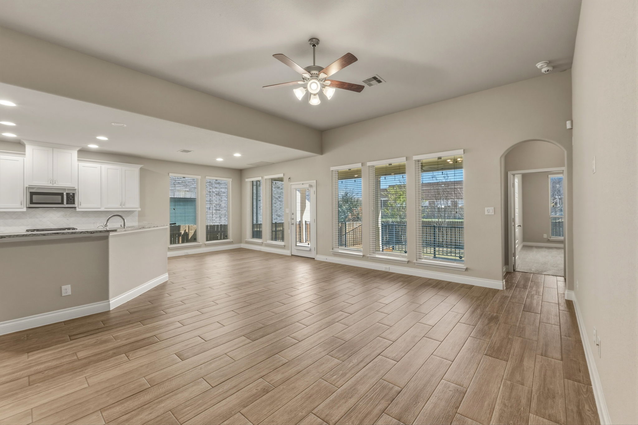 1320 Low Branch Lane Leander, TX 78641 - Photo 12 of 38 a view of an empty room with wooden floor and a kitchen