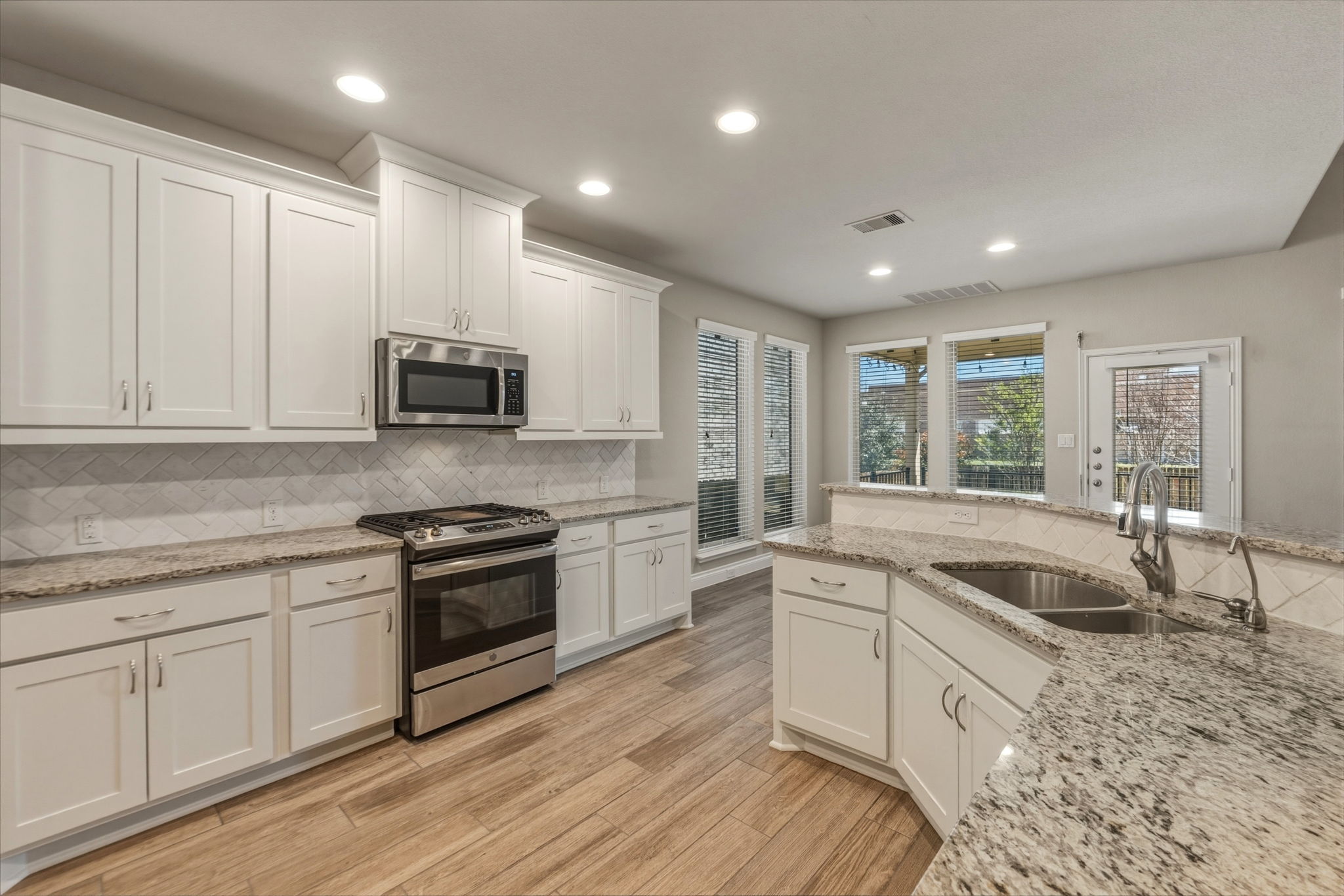 1320 Low Branch Lane Leander, TX 78641 - Photo 15 of 38 a kitchen with granite countertop white cabinets and white appliances