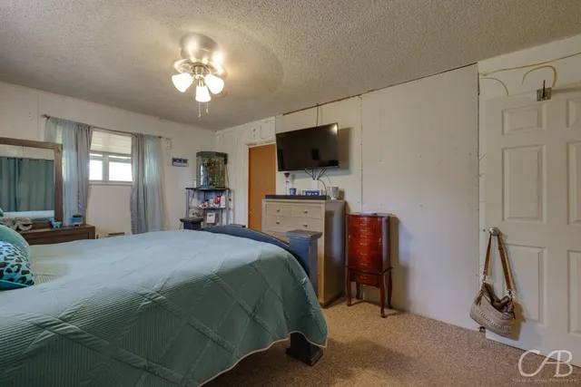 a spacious bedroom with a bed and a chandelier