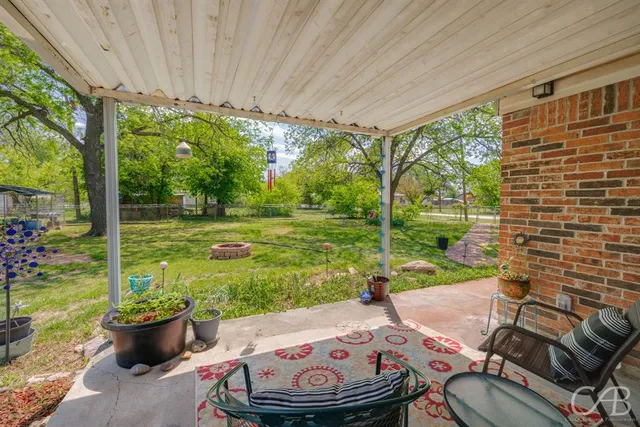a backyard of a house with table and chairs