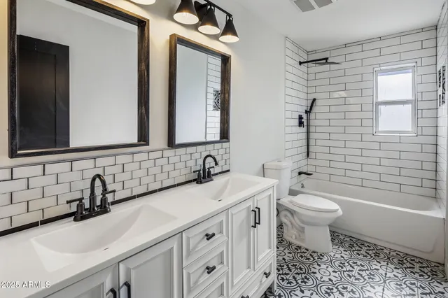 a bathroom with a double vanity sink mirror and toilet
