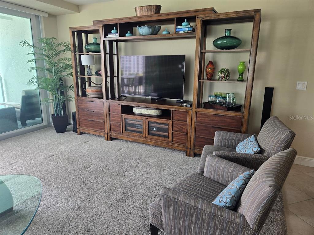 650 Golden Gate Point, Unit 301 Sarasota, FL 34236 - Photo 15 of 31 a living room with furniture and a flat screen tv