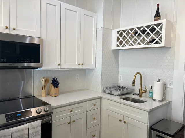 a kitchen with stainless steel appliances granite countertop a sink a stove and cabinets