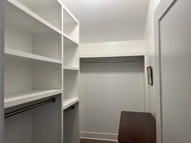 a view of walk in closet with empty racks