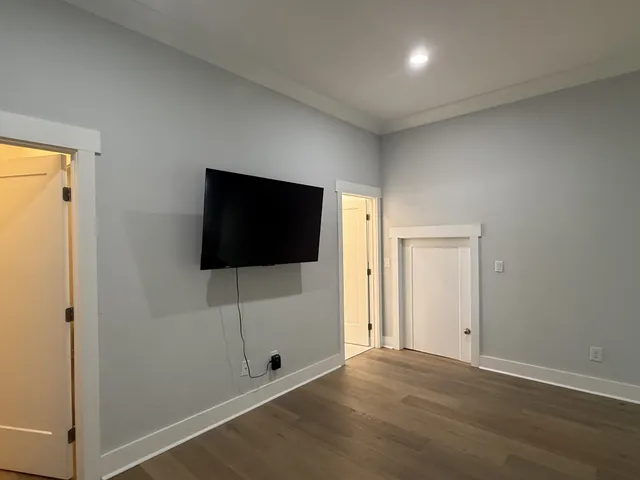 a view of a livingroom with wooden floor and flat screen tv