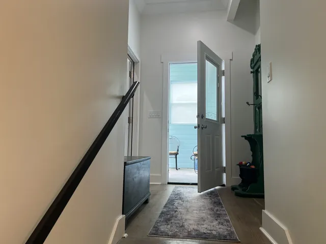 a view of hallway with stairs and wooden floor