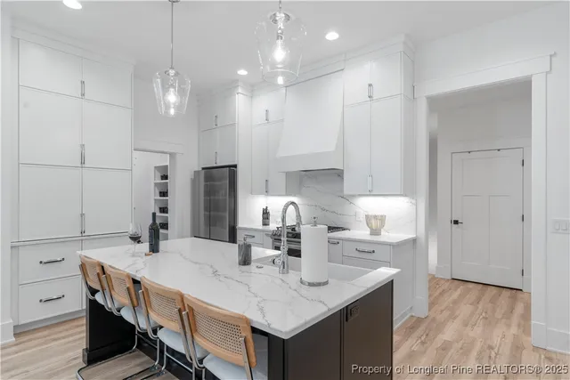 a kitchen with kitchen island a sink table and chairs