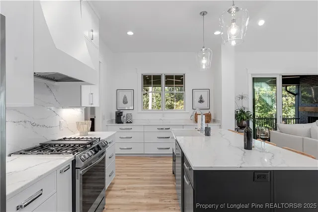 a kitchen with stainless steel appliances granite countertop a stove a sink dishwasher and a refrigerator with wooden floor