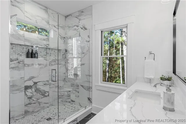a bathroom with a granite countertop shower and a sink