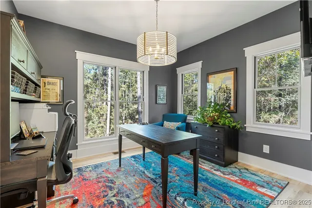 a view of a workspace with furniture and a window