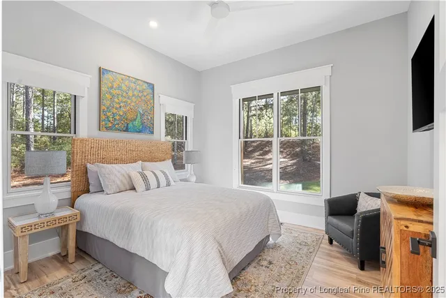 a bedroom with a large bed and a flat tv screen on dresser