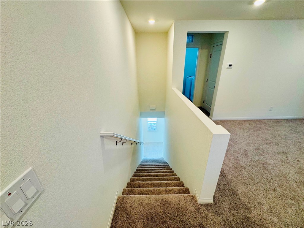 9249 Innot Avenue Las Vegas, NV 89148 - Photo 9 of 24 Carpeted stairs ascend to a landing, revealing an adjacent room with light-colored flooring.