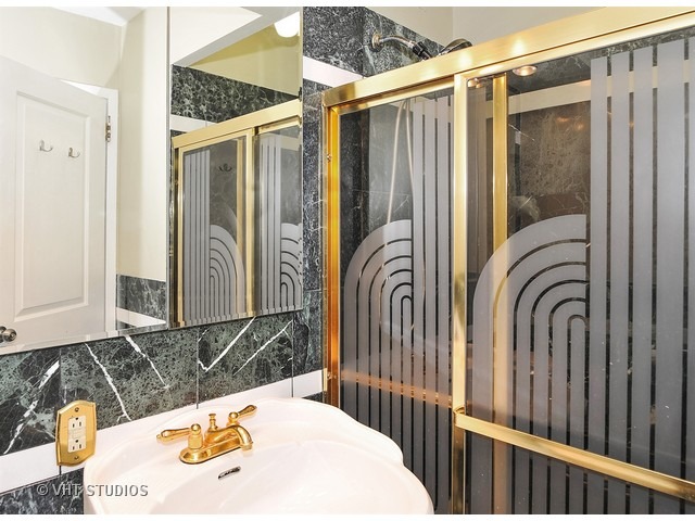 5701 North Sheridan Road, Unit 6T Chicago, IL 60660 - Photo 11 of 15 a bathroom with a sink a mirror and a shower