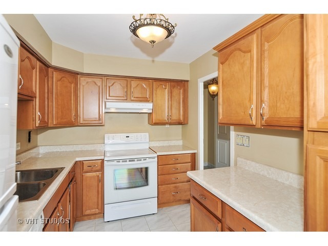 5701 North Sheridan Road, Unit 6T Chicago, IL 60660 - Photo 6 of 15 a kitchen with a stove cabinets and a refrigerator