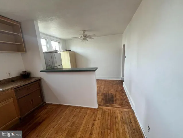a view of a kitchen with wooden floor and electronic appliances