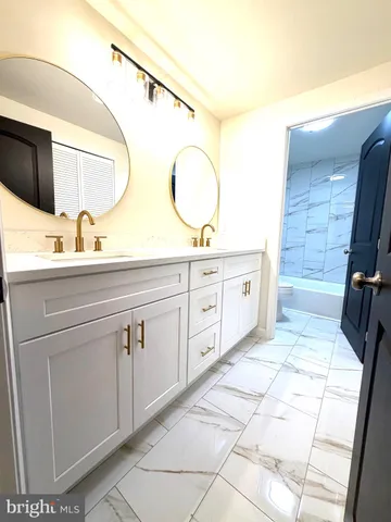 a bathroom with a double vanity sink a mirror and a shower