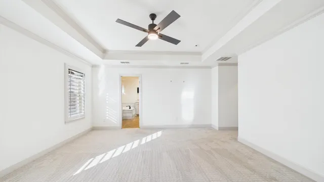 an empty room with windows and fan