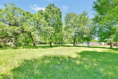 a backyard of a house with lots of green space and lake view
