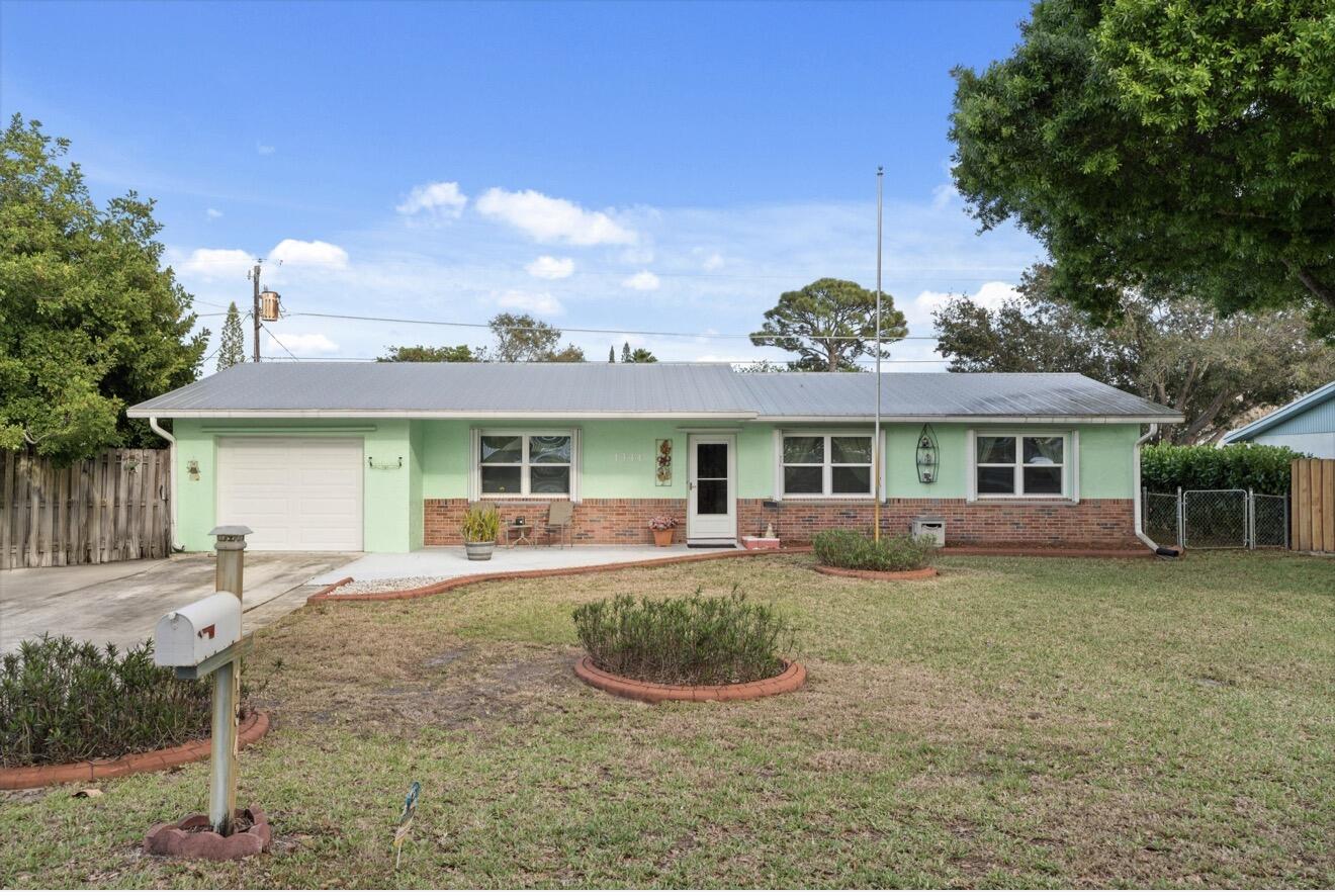 1341 Southeast Seashell Lane Stuart, FL 34996 - Photo 1 of 24 a front view of a house with garden and yard