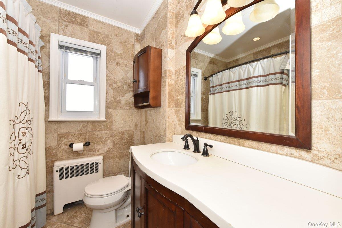 148 Simonson Road Mineola, NY 11501 - Photo 14 of 19 a bathroom with a sink toilet a mirror and bathtub