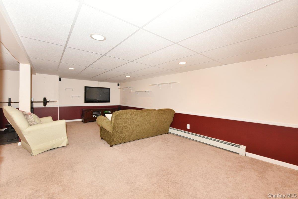 148 Simonson Road Mineola, NY 11501 - Photo 15 of 19 a living room with furniture and a flat screen tv