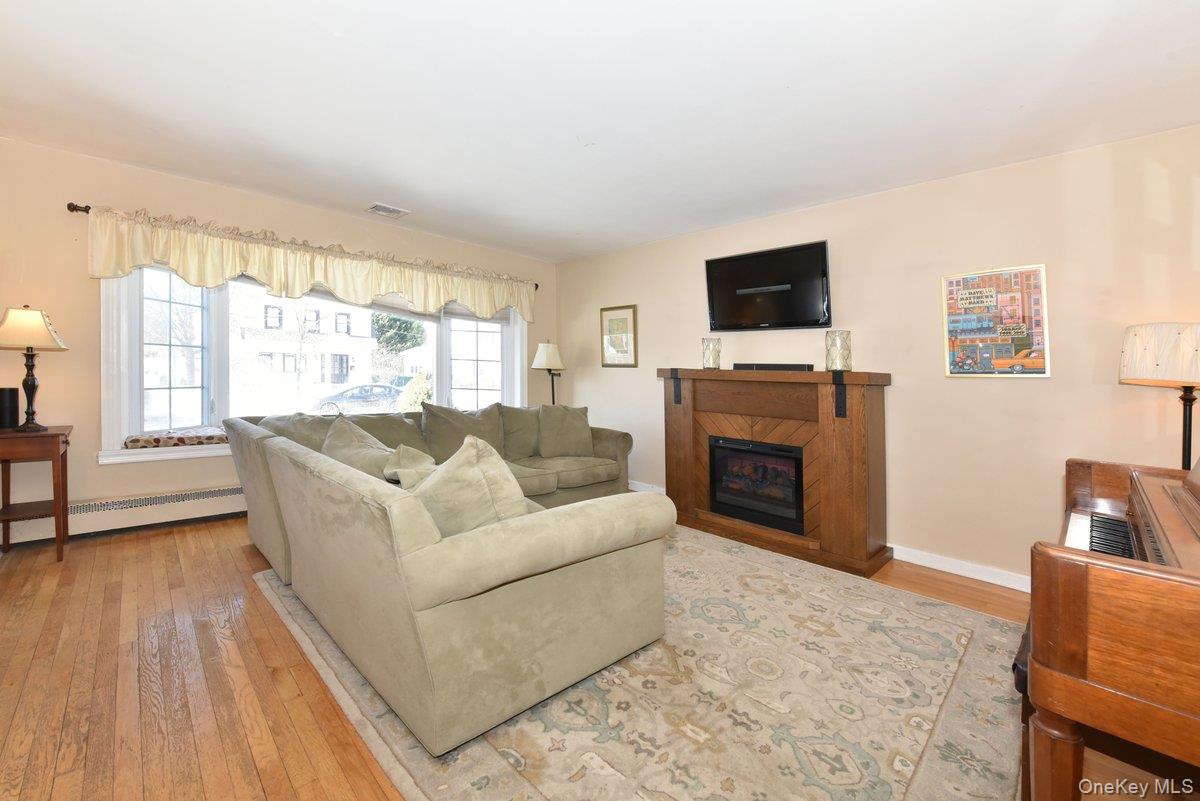 148 Simonson Road Mineola, NY 11501 - Photo 5 of 19 a living room with furniture a flat screen tv and a fireplace