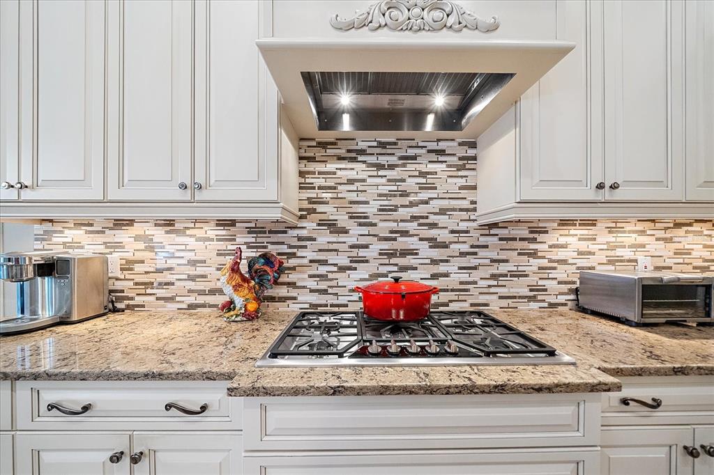 7825 Troon Court Lakewood Ranch, FL 34202 - Photo 18 of 40 a kitchen with granite countertop a stove and cabinets