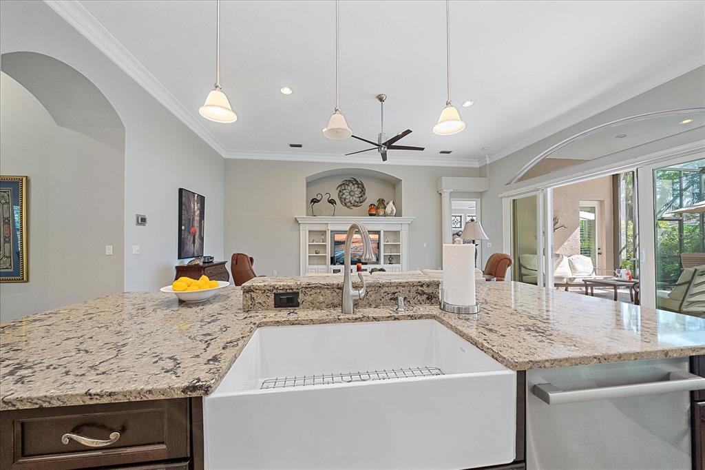 7825 Troon Court Lakewood Ranch, FL 34202 - Photo 19 of 40 a view of a kitchen with granite countertop a sink counter top space and living room