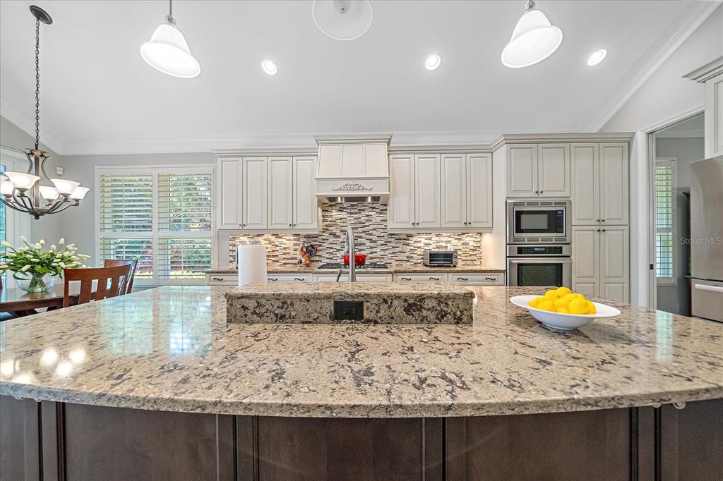 7825 Troon Court Lakewood Ranch, FL 34202 - Photo 20 of 40 a kitchen with kitchen island granite countertop a stove and cabinets