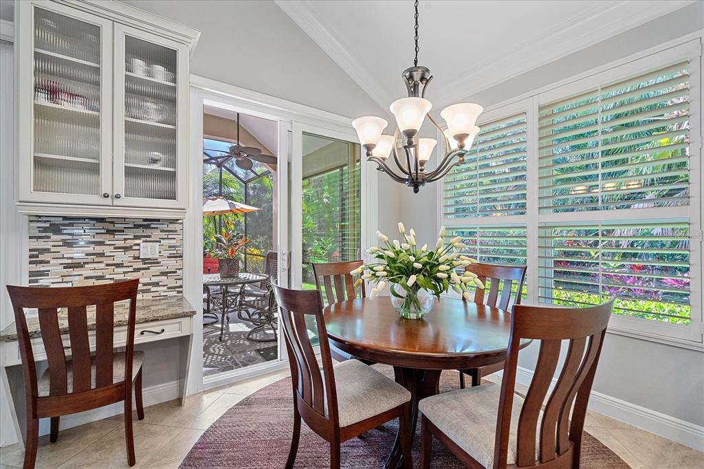 7825 Troon Court Lakewood Ranch, FL 34202 - Photo 21 of 40 a view of a dining room with furniture wooden floor and chandelier