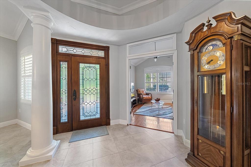 7825 Troon Court Lakewood Ranch, FL 34202 - Photo 4 of 40 a view of an entryway with wooden floor and a livingroom