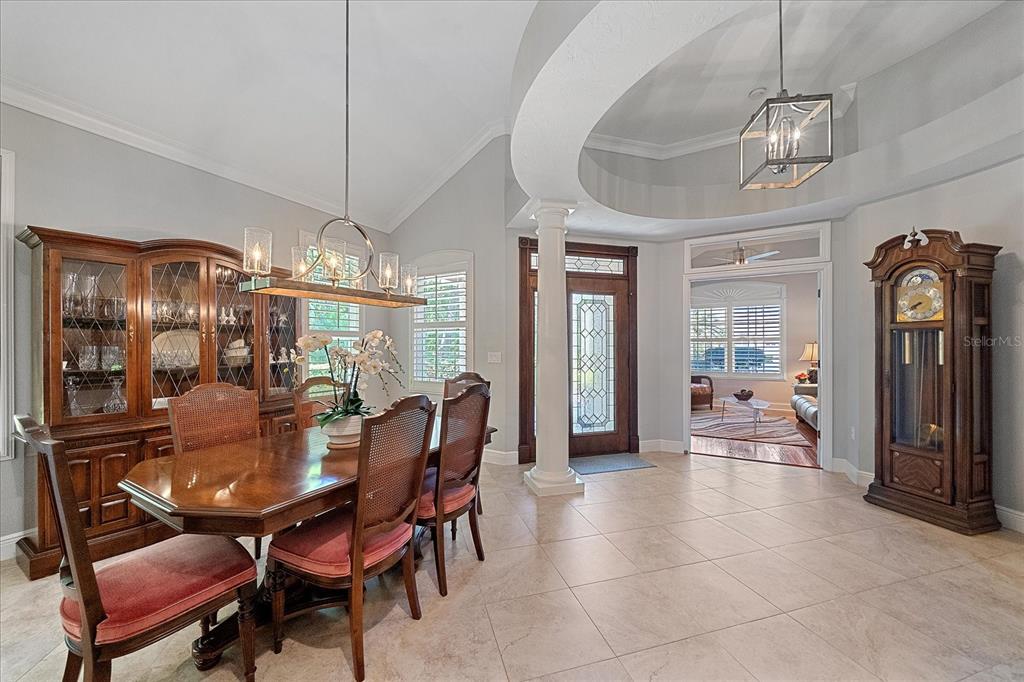 7825 Troon Court Lakewood Ranch, FL 34202 - Photo 7 of 40 a dining room with furniture a chandelier and window