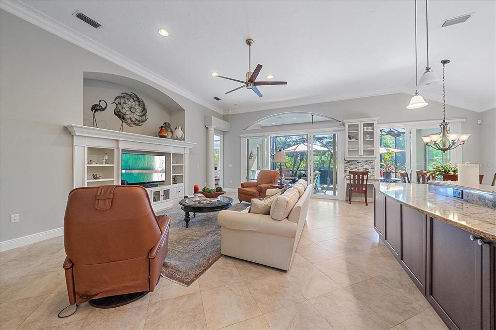 7825 Troon Court Lakewood Ranch, FL 34202 - Photo 8 of 40 a living room with furniture a large window and a ceiling fan
