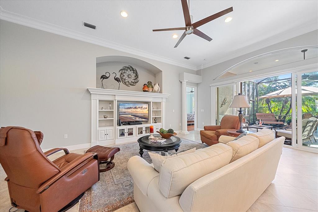 7825 Troon Court Lakewood Ranch, FL 34202 - Photo 10 of 40 a living room with furniture a ceiling fan and a large window