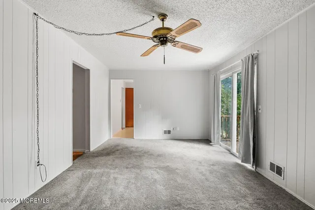 a view of a livingroom with a ceiling fan and window