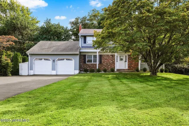 a front view of a house with a garden and trees