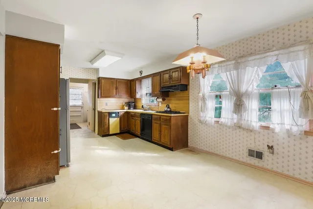 a kitchen with stainless steel appliances granite countertop a stove a sink and a refrigerator