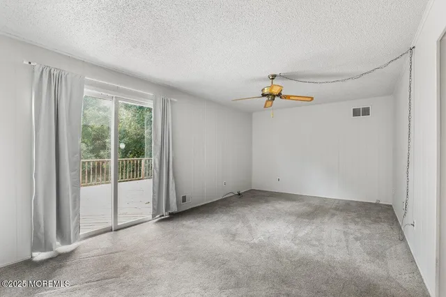 a view of a livingroom with a ceiling fan and window