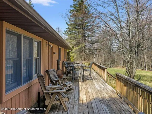 a view of deck with furniture and trees