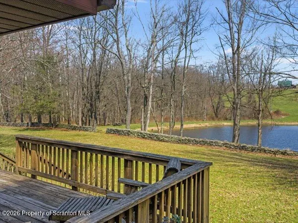 a view of a swimming pool with a patio and wooden fence