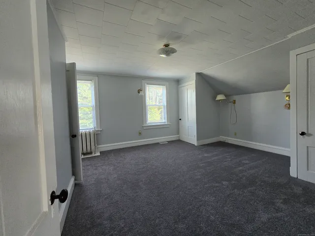 an empty room with windows and closet