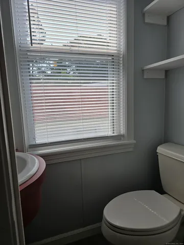 a white toilet sitting next to a window
