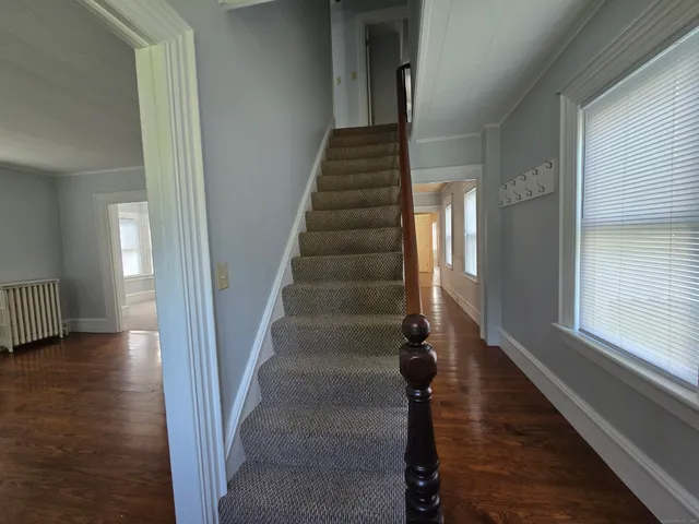 a view of entryway and hall with wooden floor