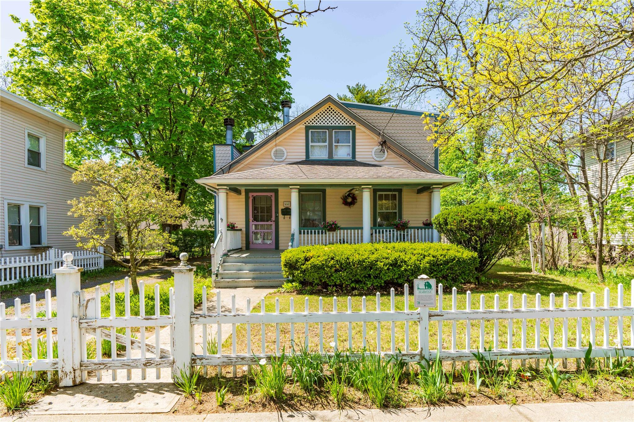 a front view of a house with a yard and potted plants