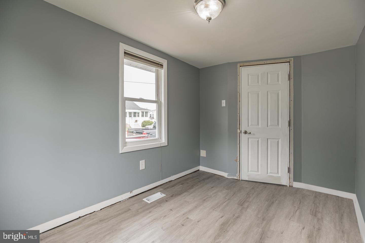 4101 9th Street North Beach, MD 20714 - Photo 11 of 19 an empty room with wooden floor cabinet and windows