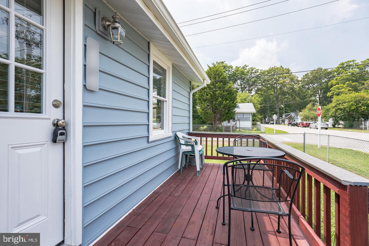 4101 9th Street North Beach, MD 20714 - Photo 16 of 19 a balcony with wooden floor and outdoor seating