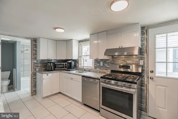 a kitchen with stainless steel appliances a stove a sink and a refrigerator
